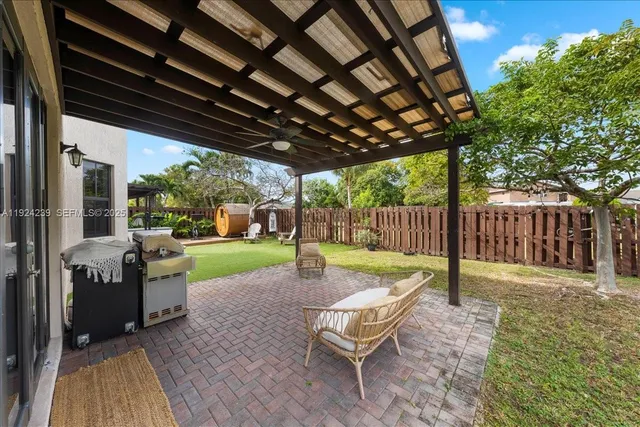 a view of a chairs and table in the patio with a small yard