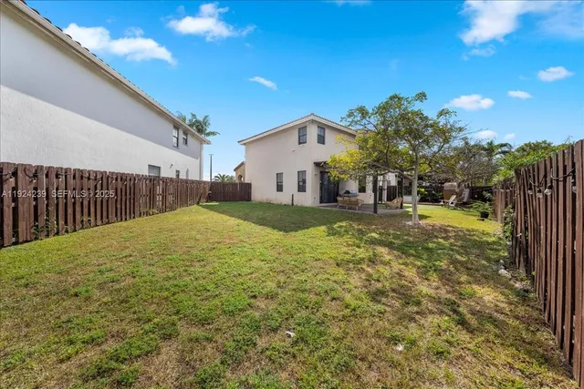 a view of a house with large windows and a yard