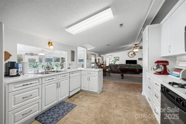 a kitchen with sink cabinets and stove top oven