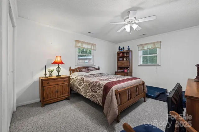 a spacious bedroom with a bed and a chandelier