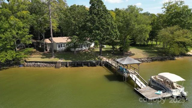 an aerial view of a house with swimming pool and lake view