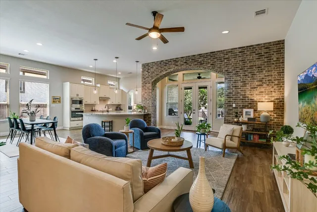 a living room with furniture kitchen view and a large window