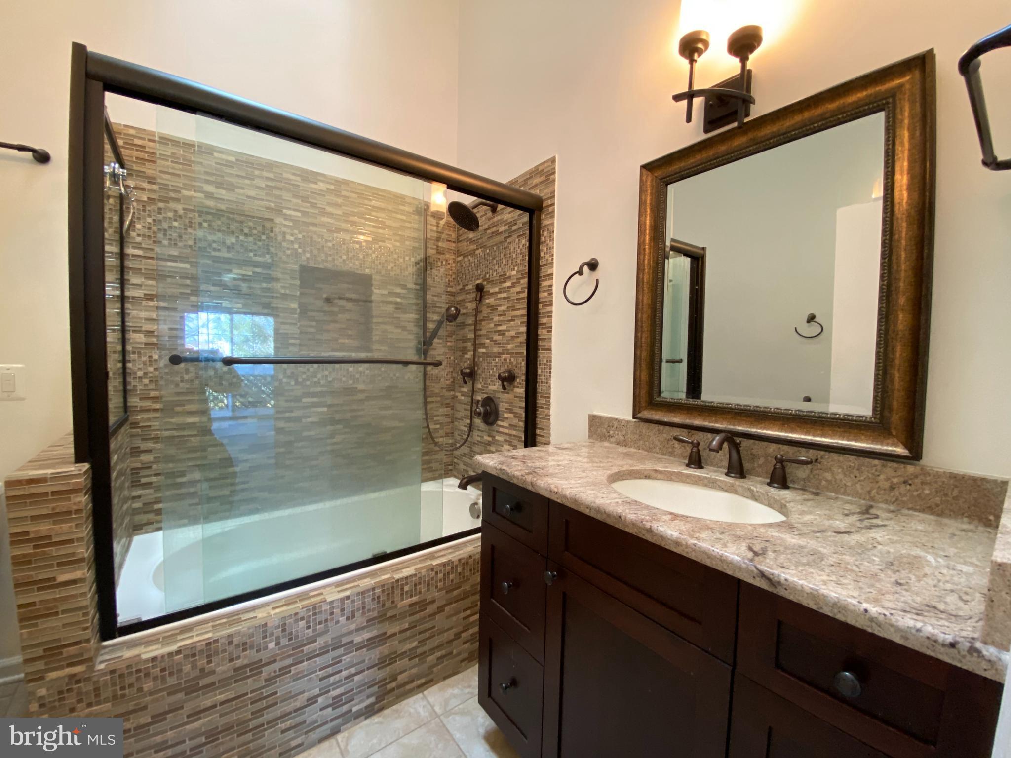 12944 Grays Pointe Road, Unit 12944C Fairfax, VA 22033 - Photo 10 of 16 a bathroom with a granite countertop sink mirror and shower