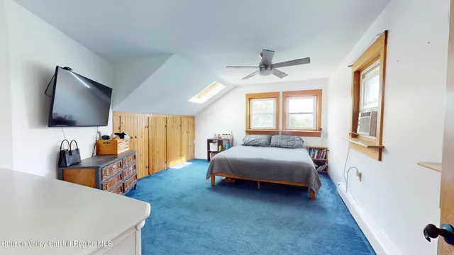 a bedroom with a bed and a flat tv screen on dresser