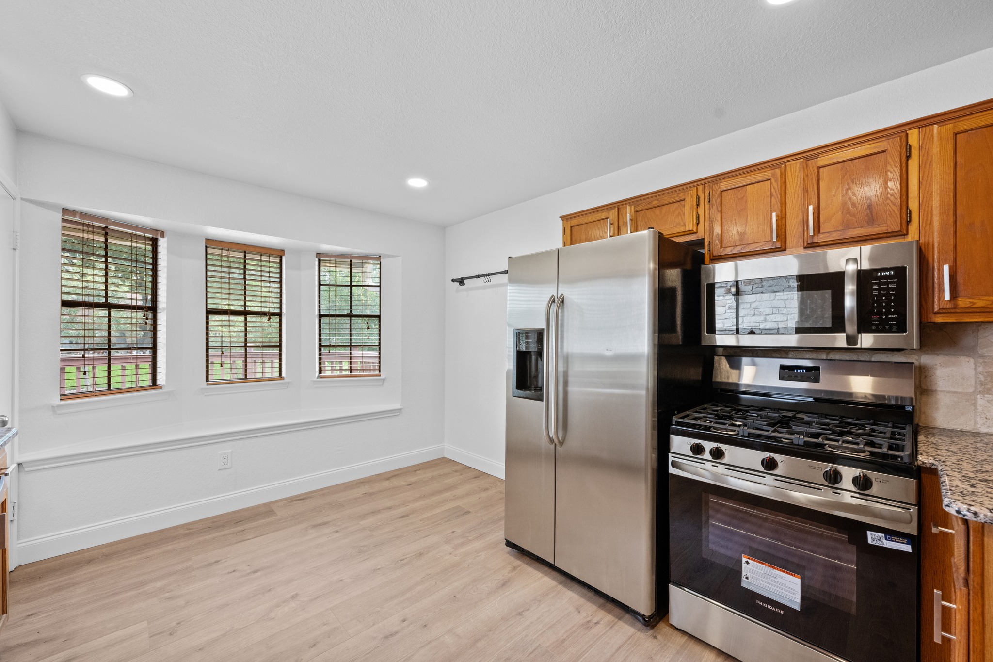 7210 Smokey Hill Road Austin, TX 78736 - Photo 12 of 29 A well-lit kitchen with modern stainless steel appliances and durable flooring awaits culinary adventures.