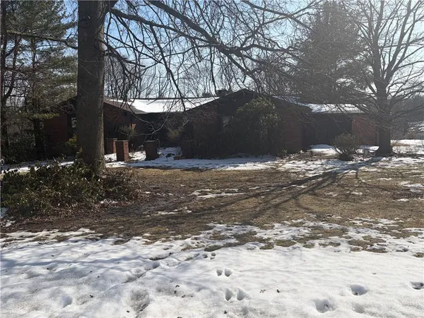 a view of a yard covered with snow in front of house