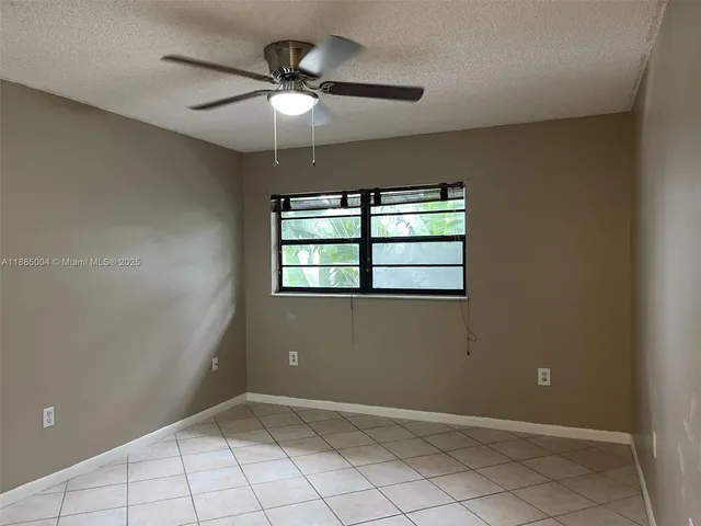 an empty room with closet and a chandelier fan