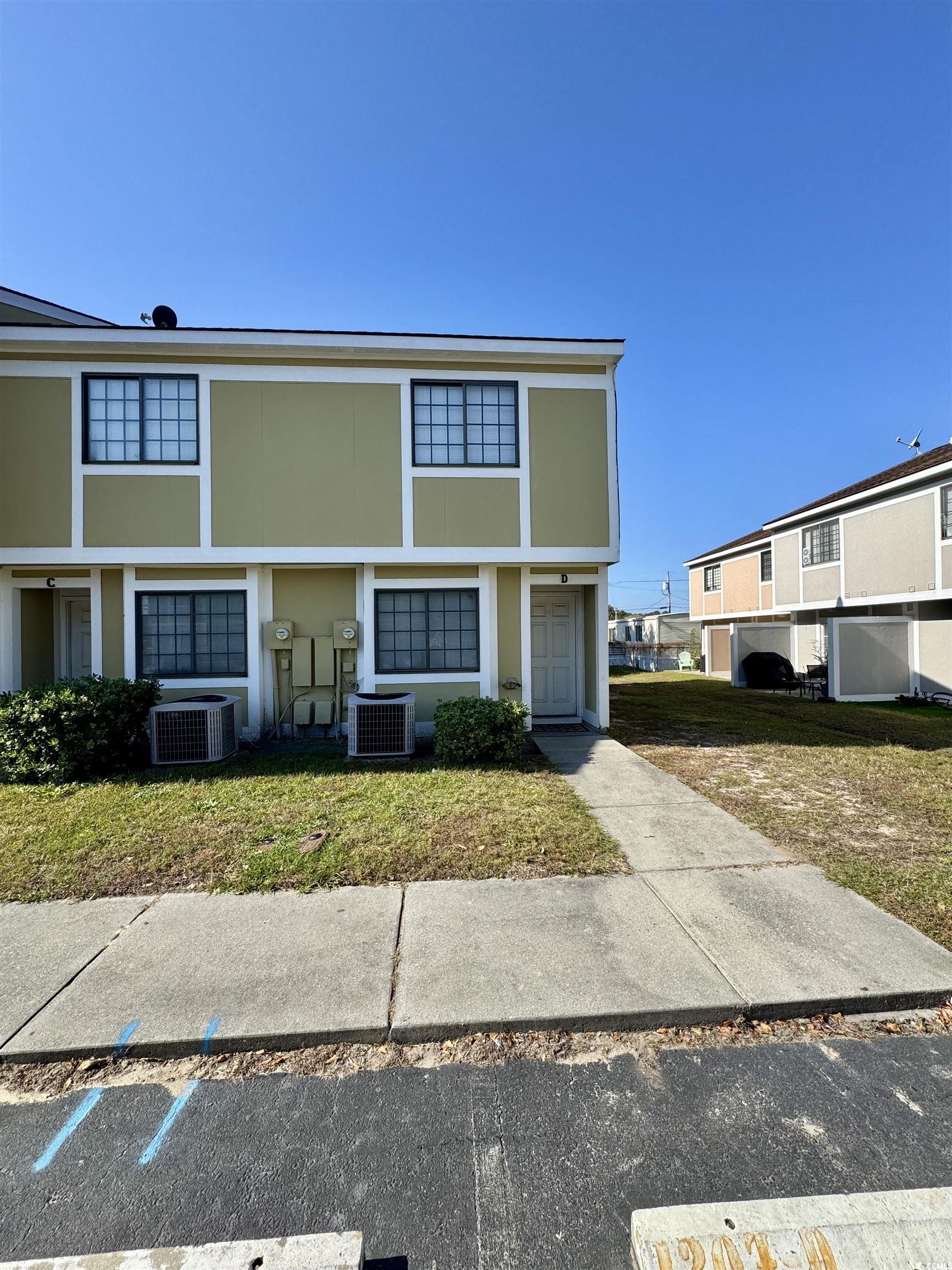 1207 Pinegrove Drive, Unit C Myrtle Beach, SC 29577 - Photo 3 of 16 View of front of house featuring stucco siding and a front lawn