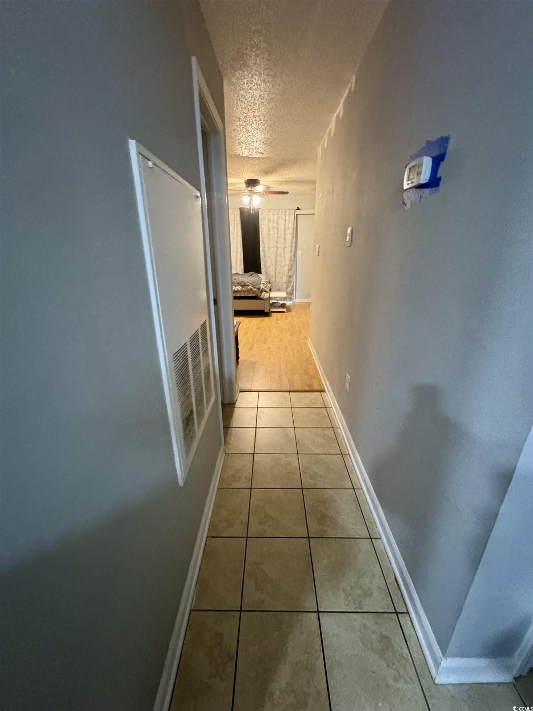 1207 Pinegrove Drive, Unit C Myrtle Beach, SC 29577 - Photo 4 of 16 Hall with a textured ceiling and light tile patterned floors