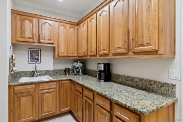 a kitchen with granite countertop stainless steel appliances granite countertop a sink and dishwasher with wooden cabinets