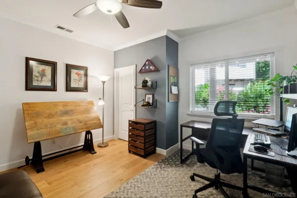 a view of a workspace with furniture and a window