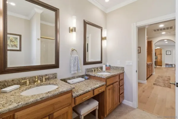 a bathroom with a granite countertop double vanity sink and a mirror