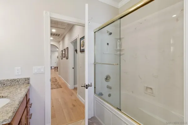 a bathroom with a granite countertop shower mirror and a bathtub