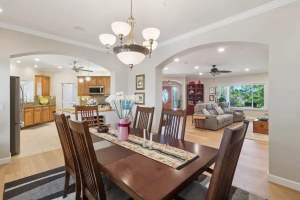 a view of a dining room with furniture a chandelier and wooden floor