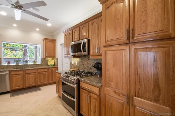 a kitchen with stainless steel appliances granite countertop a stove a sink and a refrigerator