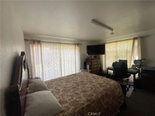 a bedroom with a bed and large windows