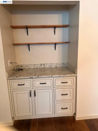 a kitchen with cabinets appliances and a wooden floor