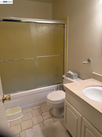 a bathroom with a granite countertop sink toilet and a mirror