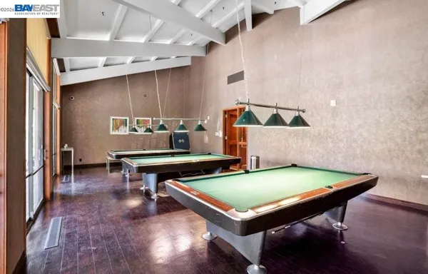 a room with pool table and windows