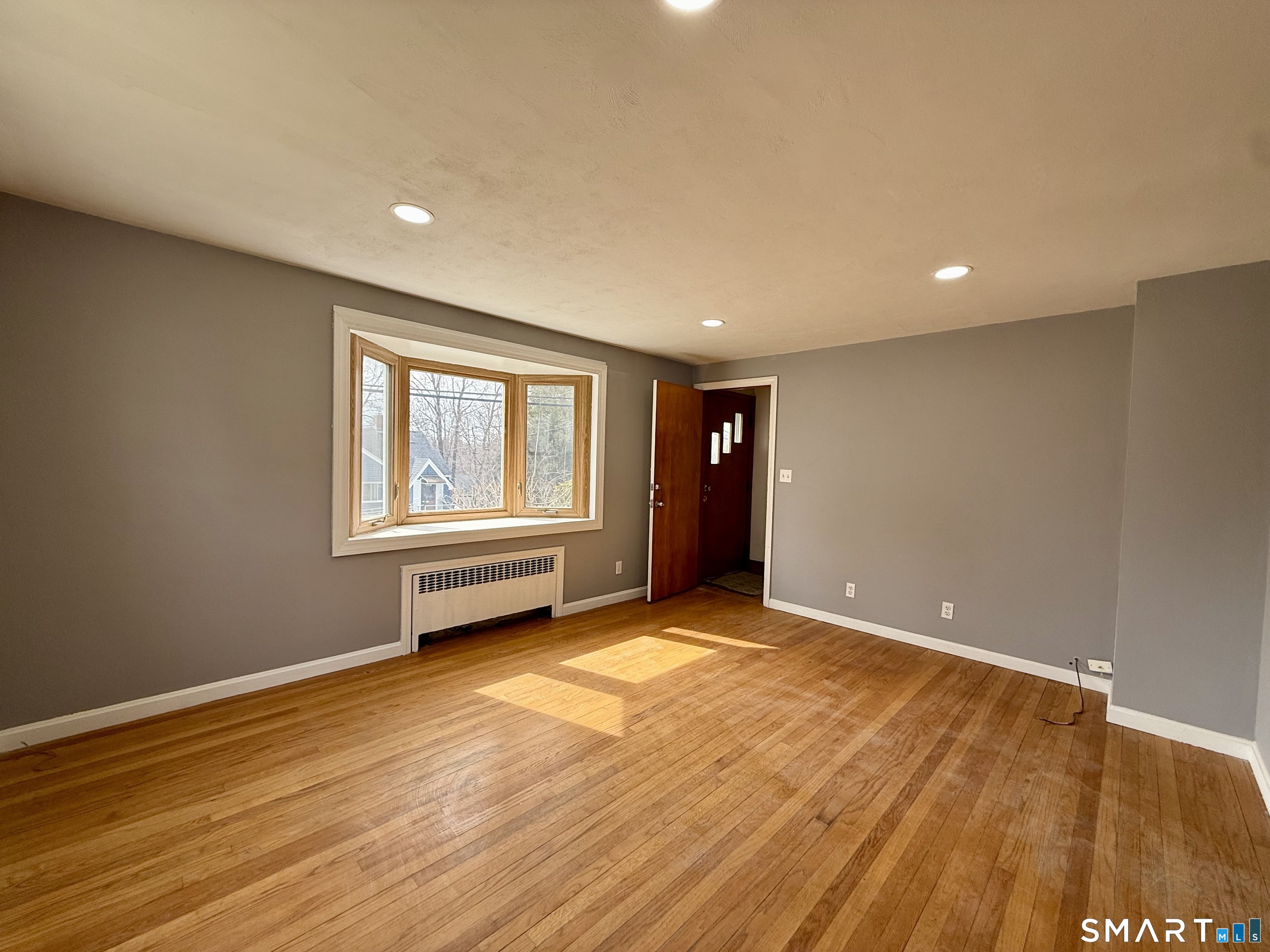 37 Alexander Avenue, Unit 1 Waterbury, CT 06705 - Photo 2 of 14 a view of an empty room with wooden floor and a window