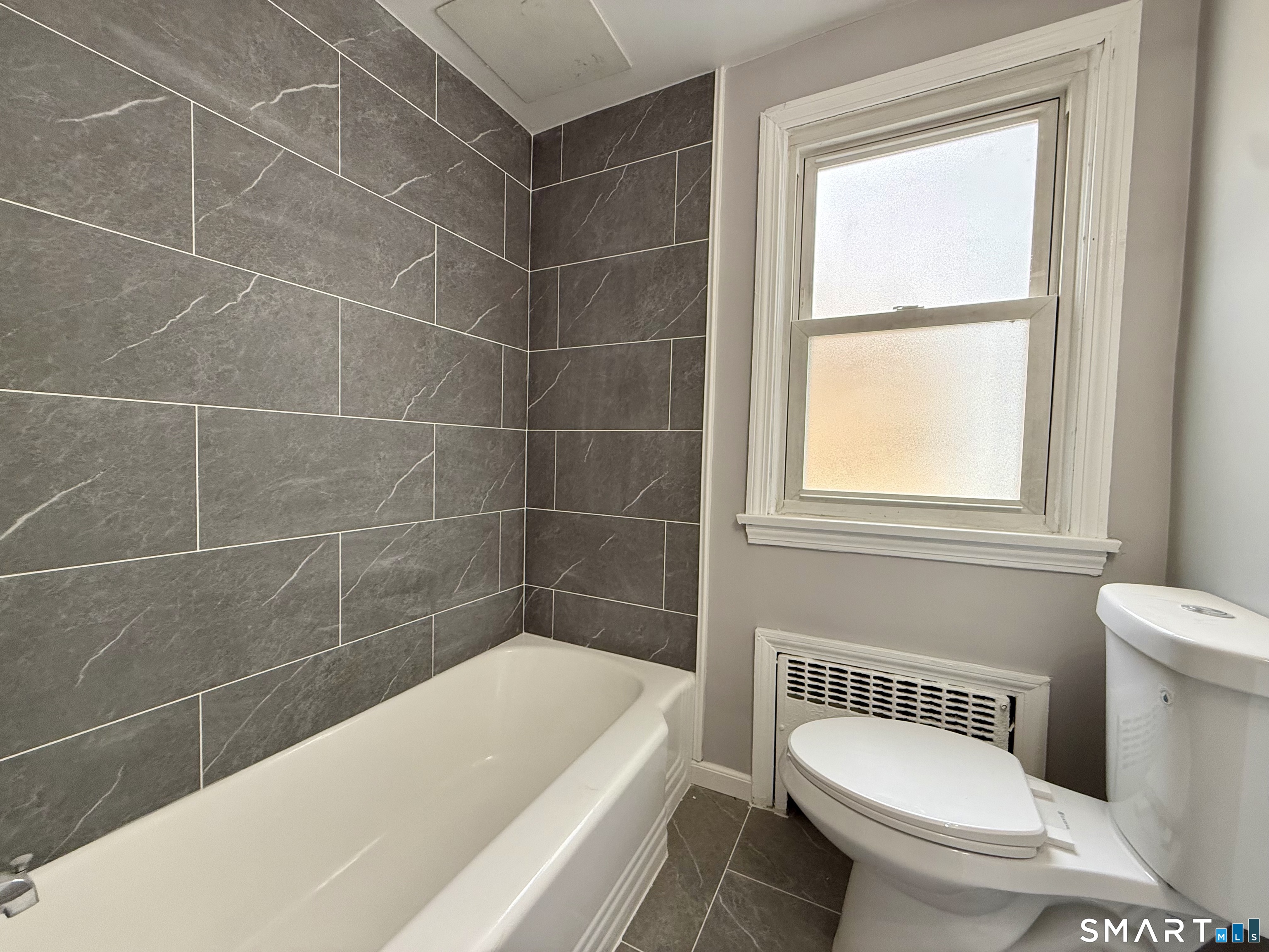 37 Alexander Avenue, Unit 1 Waterbury, CT 06705 - Photo 10 of 14 a bathroom with a bathtub and window