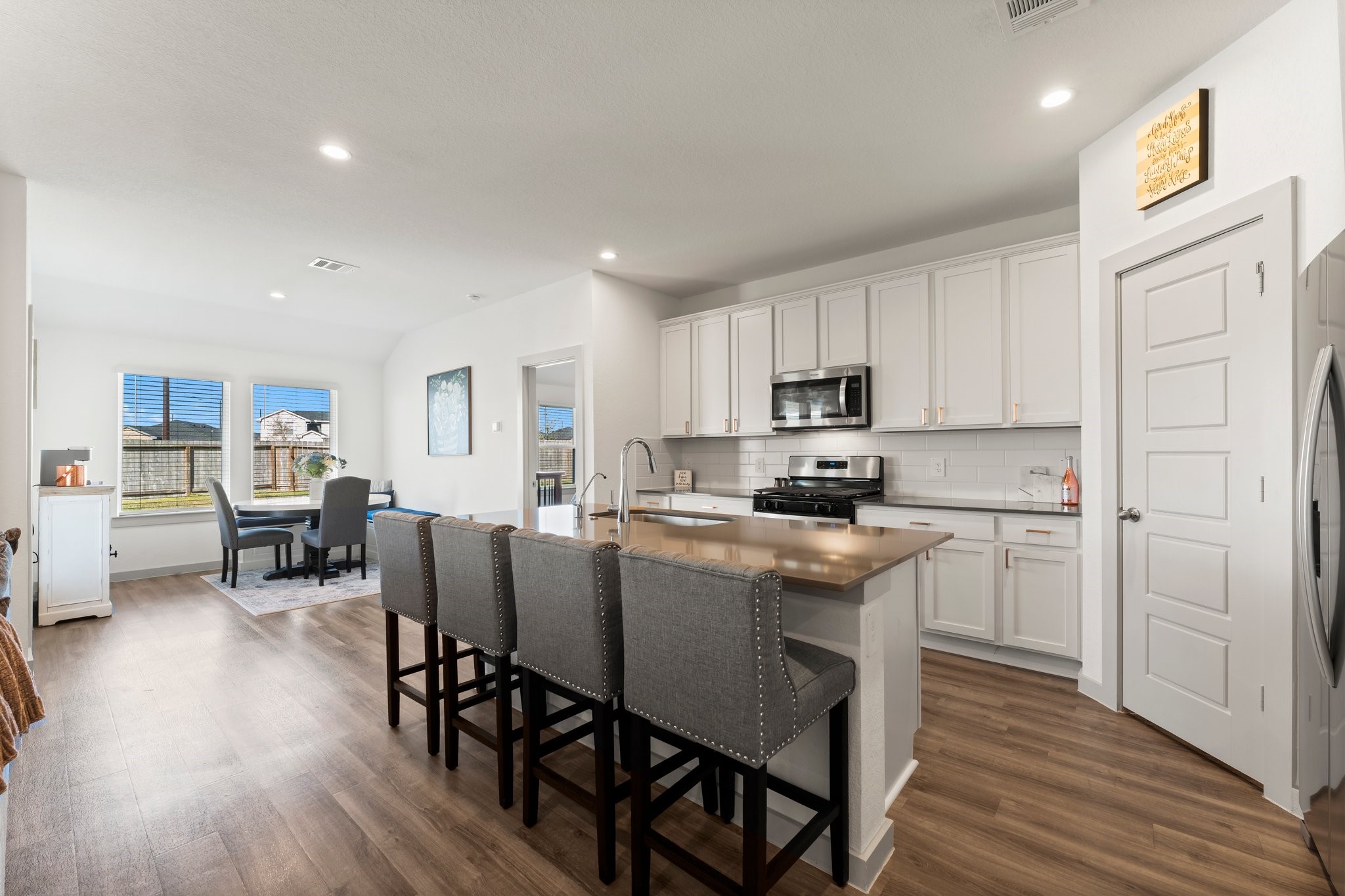 a kitchen with stainless steel appliances granite countertop a table chairs refrigerator sink and cabinets