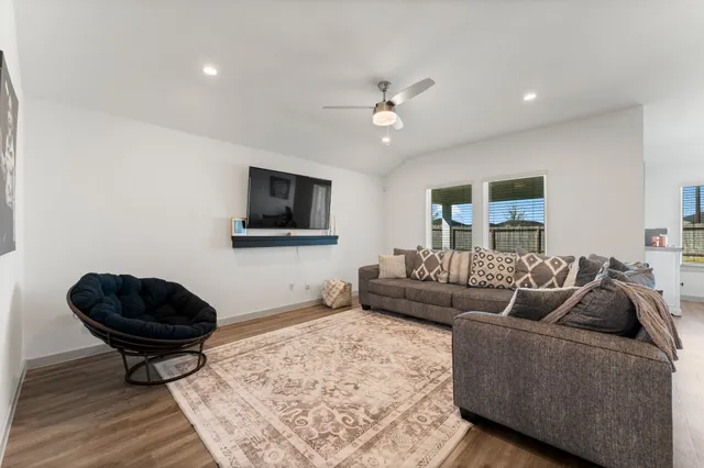 a living room with furniture a rug and a flat screen tv