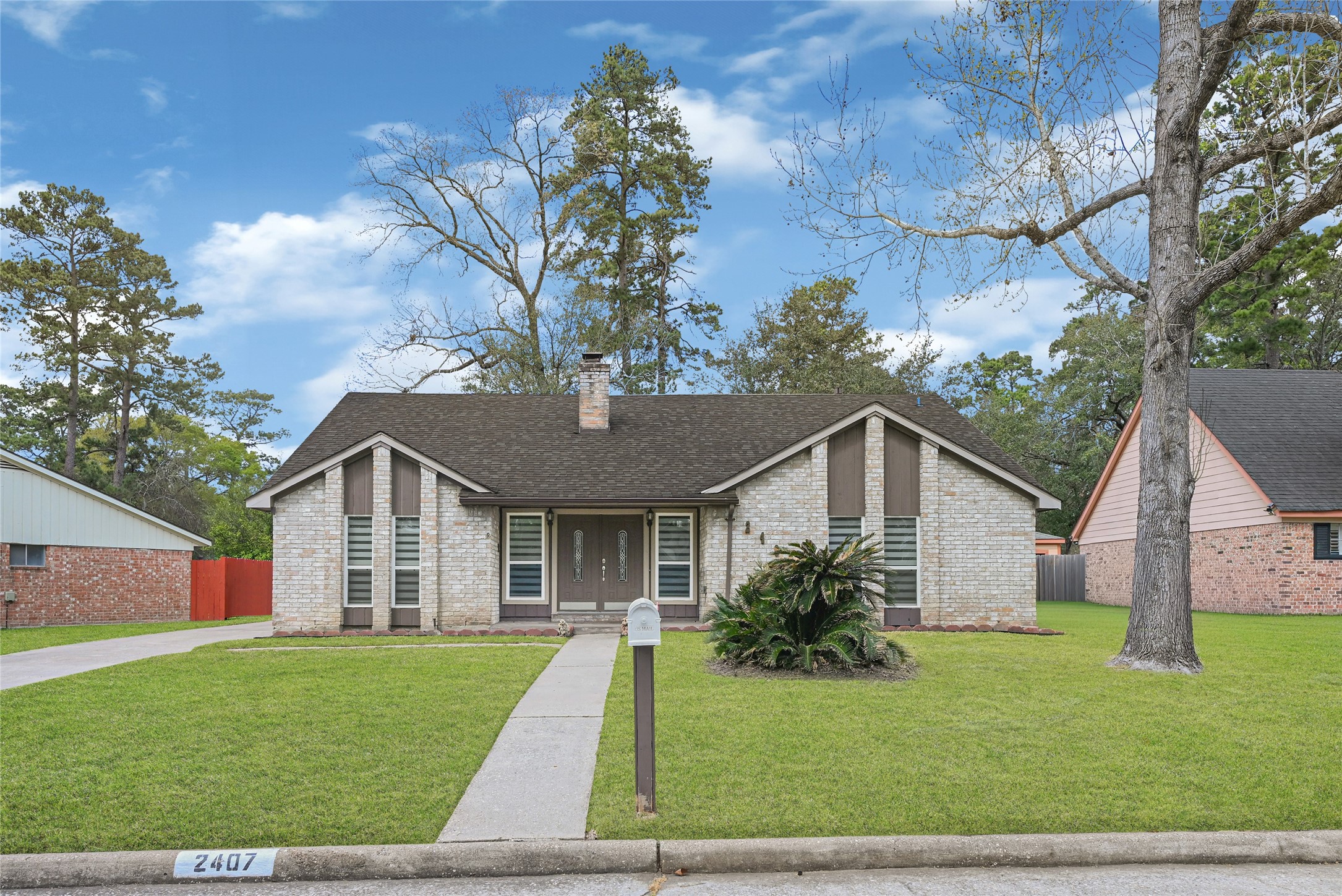 2407 Rambling Brook Drive Spring, TX 77373 - Photo 1 of 49 a view of a yard in front of a house with plants and large tree