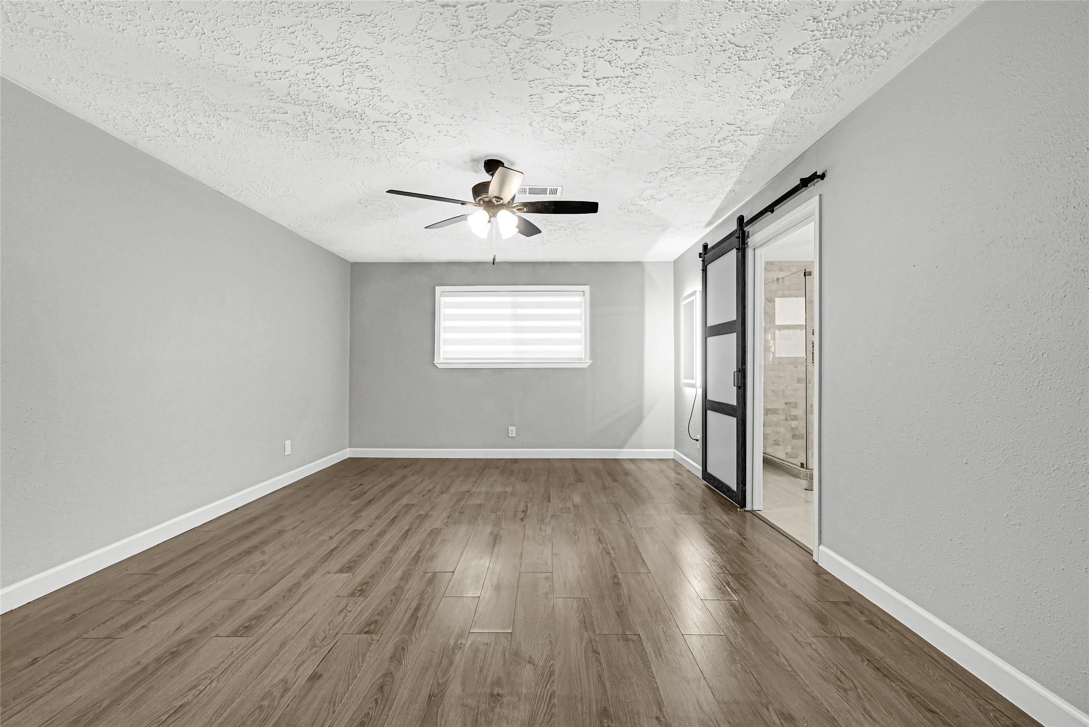 2407 Rambling Brook Drive Spring, TX 77373 - Photo 25 of 49 an empty room with wooden floor chandelier fan and windows