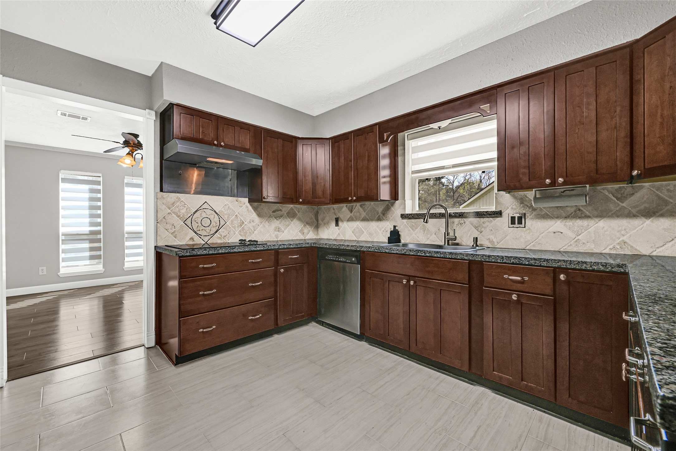 2407 Rambling Brook Drive Spring, TX 77373 - Photo 34 of 49 a kitchen with granite countertop wooden cabinets and a sink