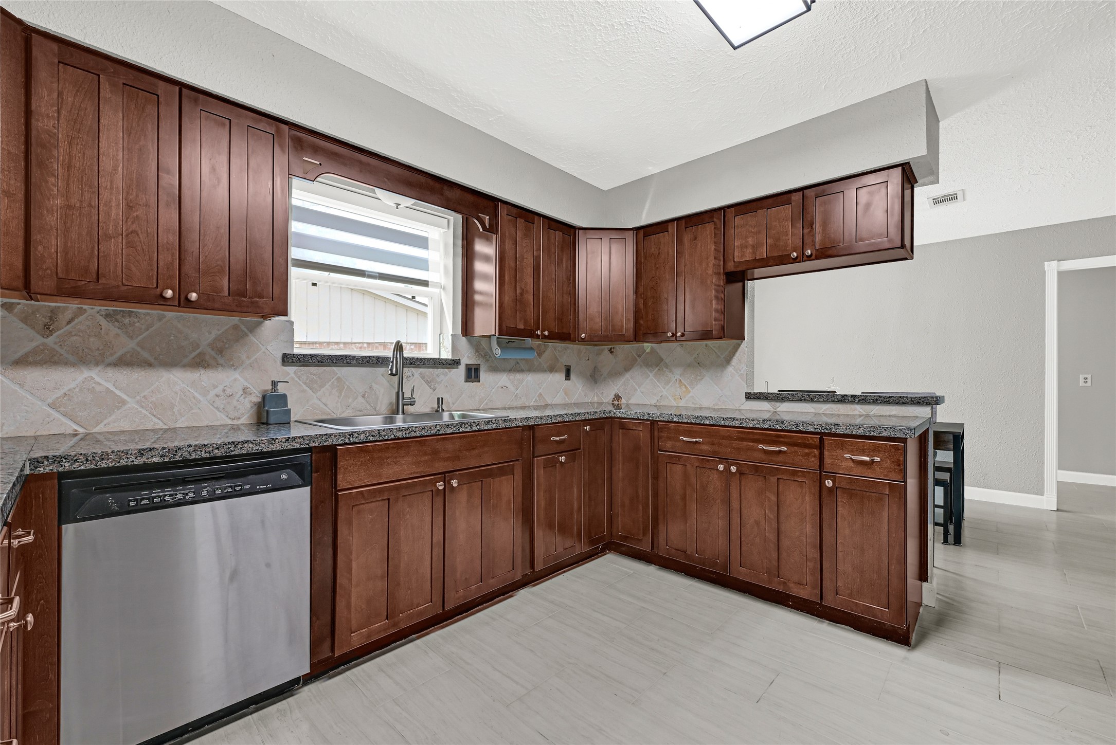 2407 Rambling Brook Drive Spring, TX 77373 - Photo 35 of 49 a kitchen with stainless steel appliances granite countertop wooden cabinets a sink and dishwasher a oven with wooden floors