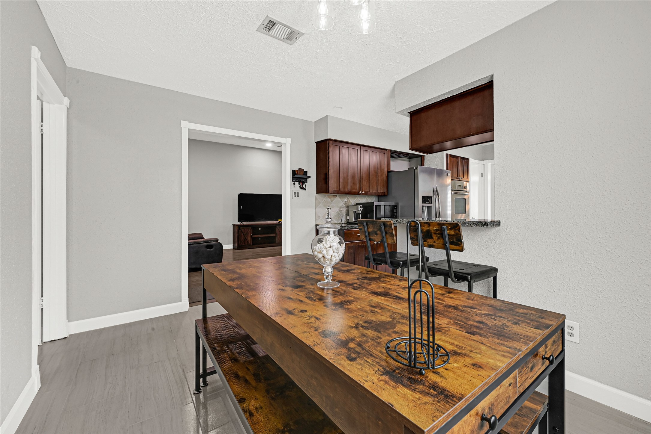 2407 Rambling Brook Drive Spring, TX 77373 - Photo 6 of 49 a room with kitchen island stainless steel appliances wooden floor dining table and chairs