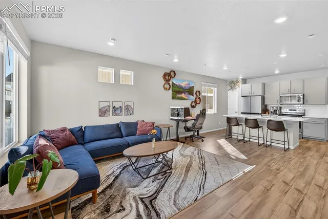 a living room with furniture kitchen and a table