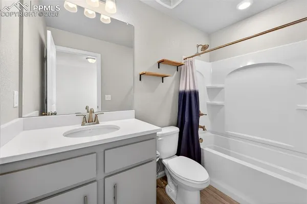 a bathroom with a sink a toilet a mirror and shower