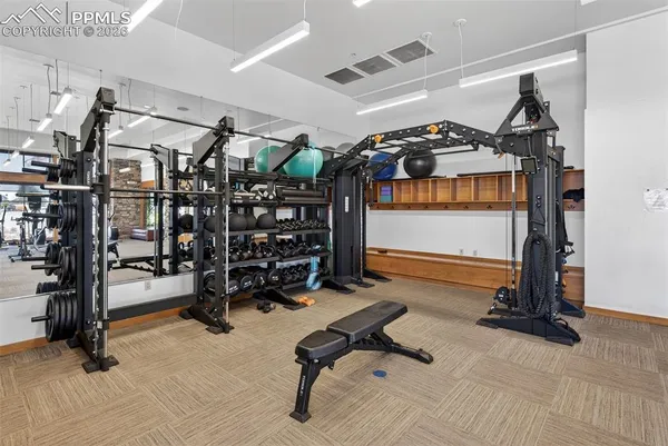 a room with gym equipment and large mirror