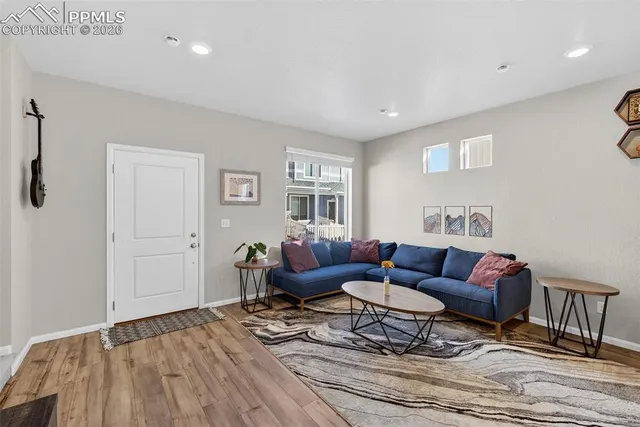 a living room with furniture and a wooden floor