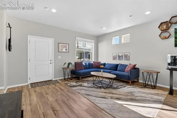 a living room with furniture a flat screen tv and a window
