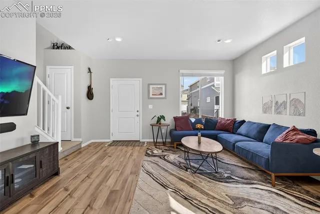 a living room with furniture a flat screen tv and a window