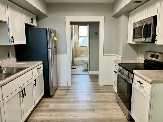 a kitchen with a refrigerator stove and sink