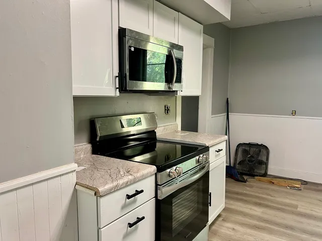 a kitchen with stainless steel appliances granite countertop a stove and a microwave