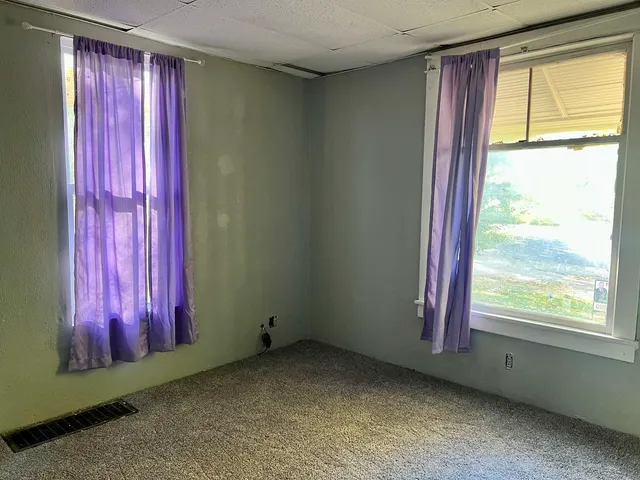 a view of a room with large windows and bed