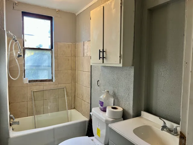 a view of backyard of house with wooden fence