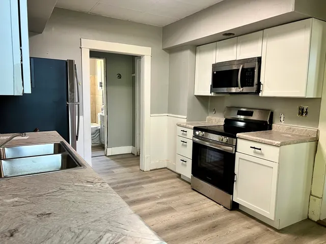a kitchen with stainless steel appliances granite countertop a stove and a microwave