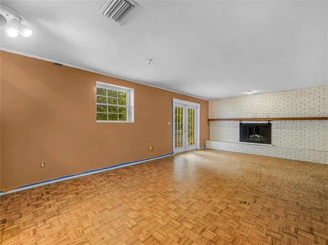a view of an empty room with a window and fireplace