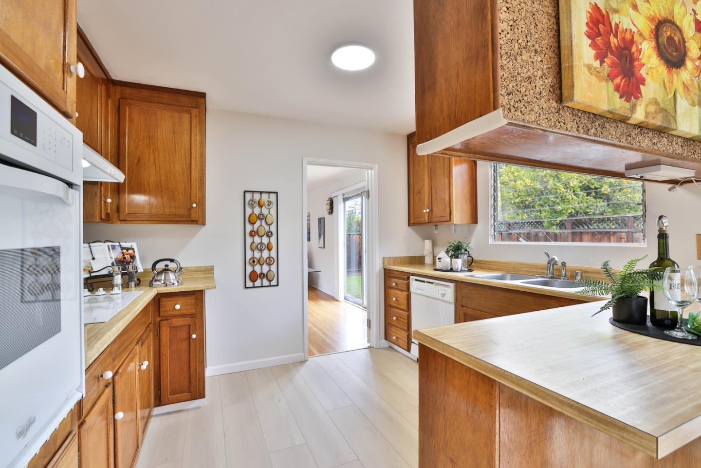 10326 Cherry Tree Lane Cupertino, CA 95014 - Photo 17 of 32 a kitchen with stainless steel appliances granite countertop a sink a stove and a wooden floors