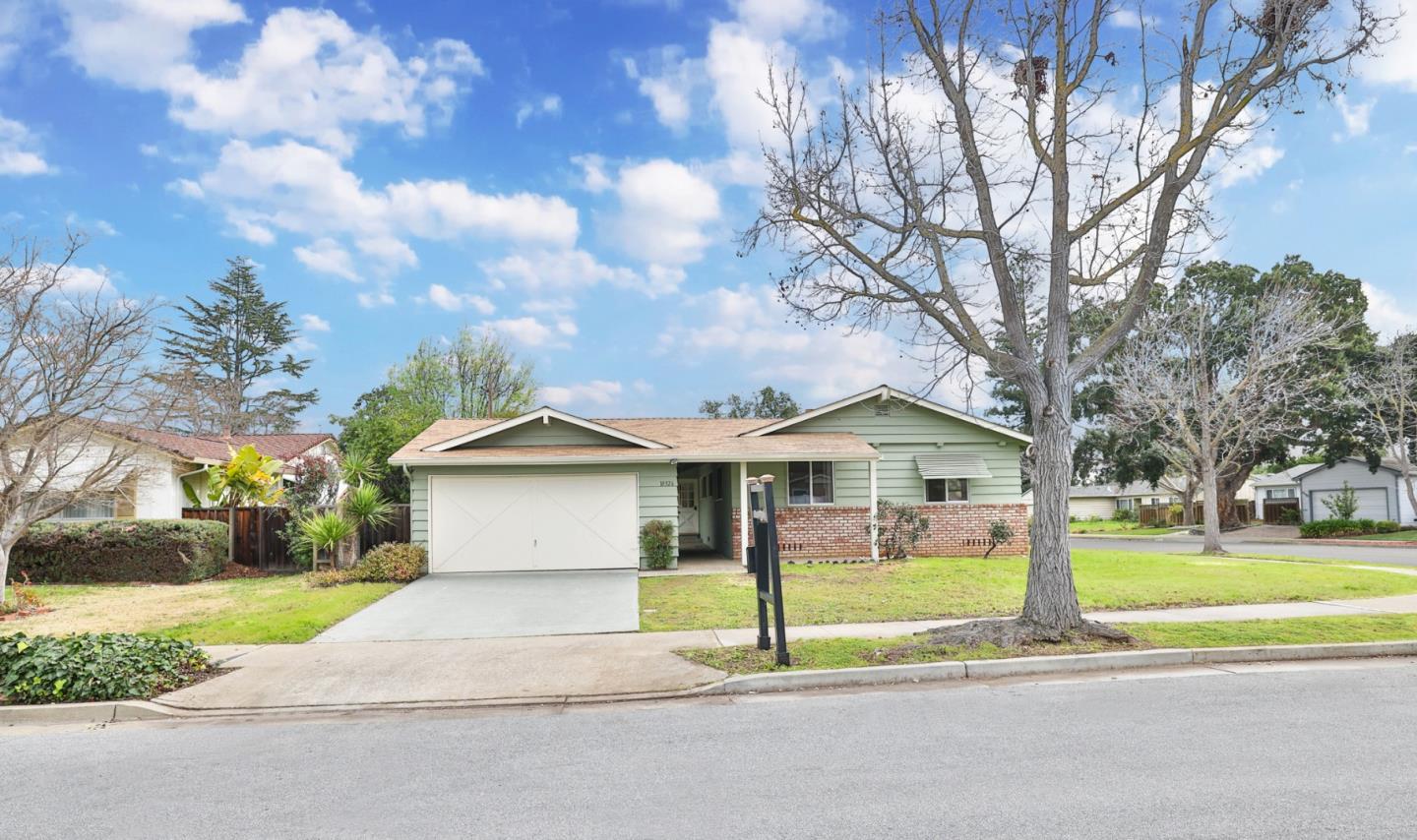 10326 Cherry Tree Lane Cupertino, CA 95014 - Photo 2 of 32 a front view of a house with a yard and garage