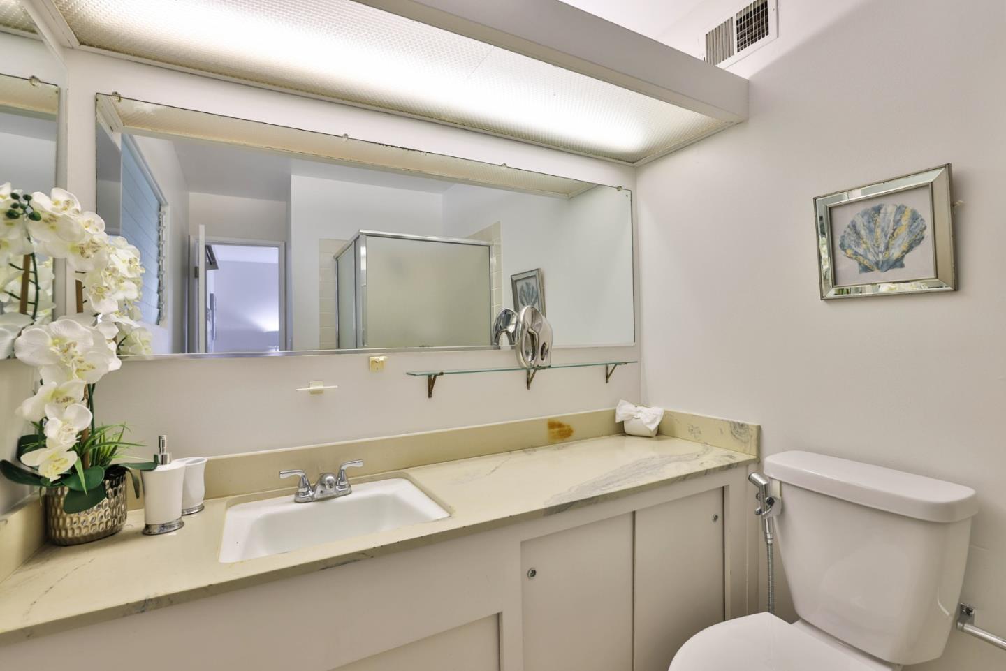 10326 Cherry Tree Lane Cupertino, CA 95014 - Photo 27 of 32 a bathroom with a granite countertop sink mirror and toilet
