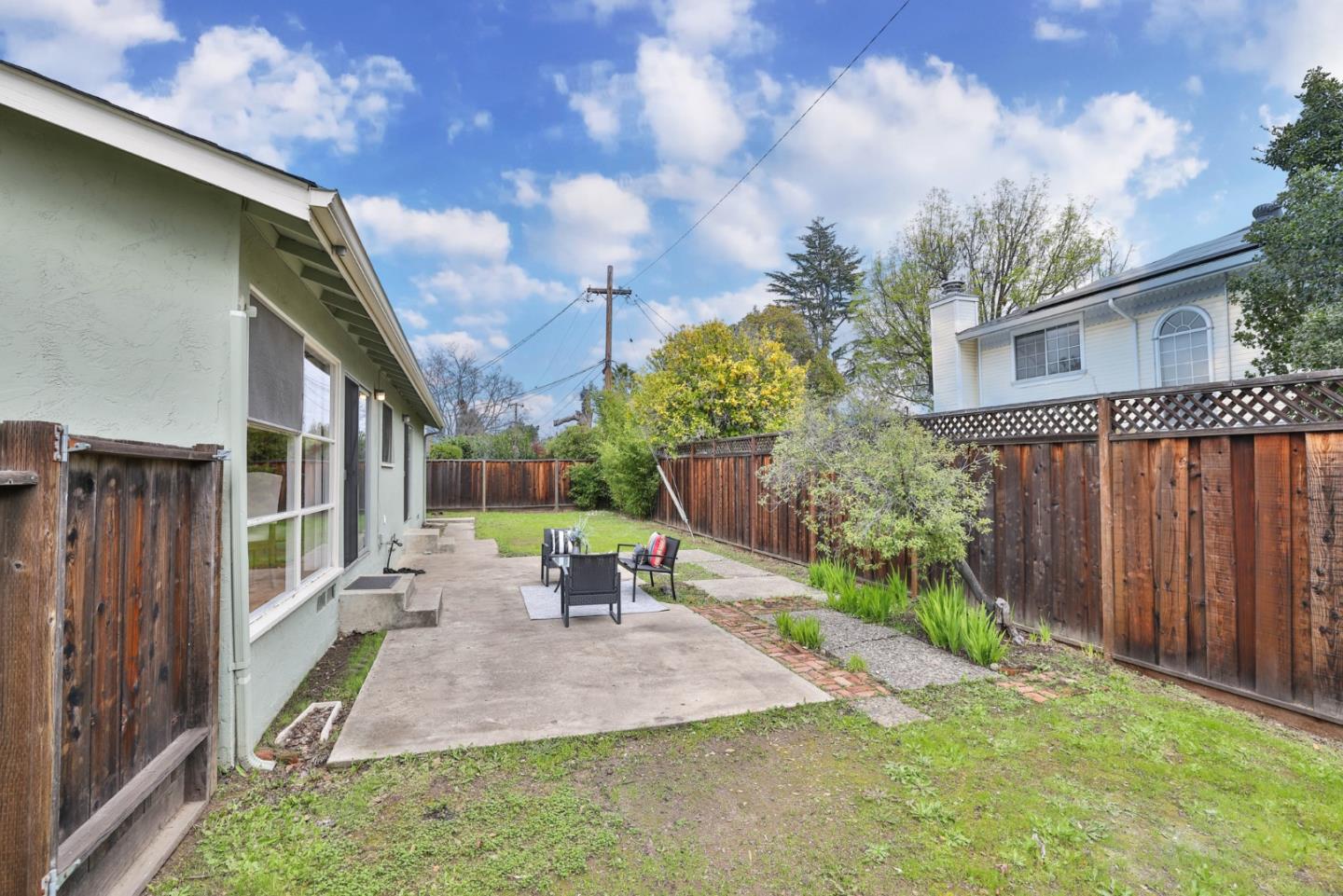 10326 Cherry Tree Lane Cupertino, CA 95014 - Photo 29 of 32 a view of a patio with table and chairs with wooden fence and plants
