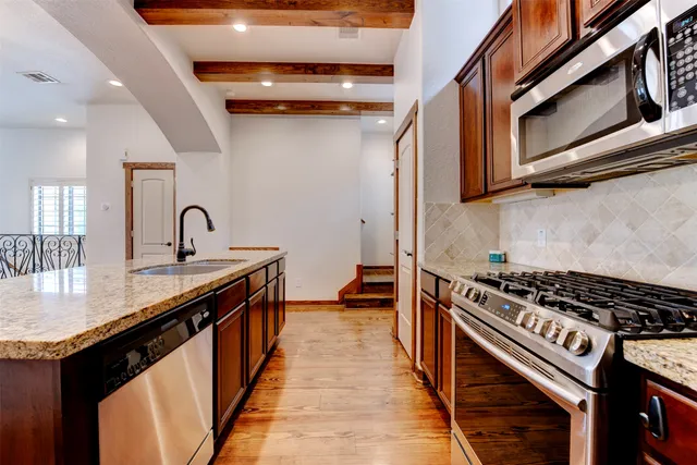 a living room with furniture kitchen view and a chandelier