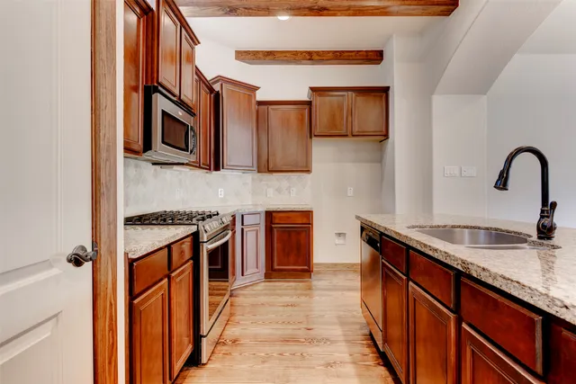 a kitchen with stainless steel appliances granite countertop a stove microwave and refrigerator